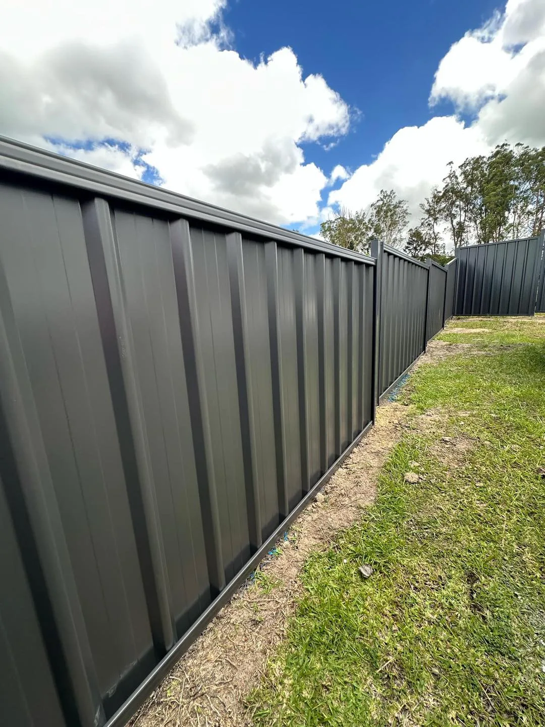 Retaining wall built into a garden bed against a fence