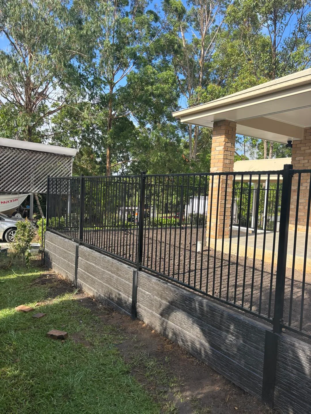 Steel fencing and retaining wall along a new lawn