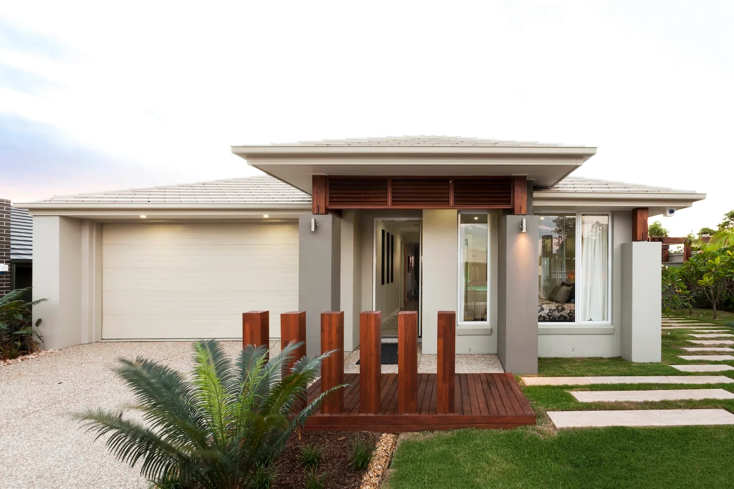 Timber deck entrance to a landscaped front yard